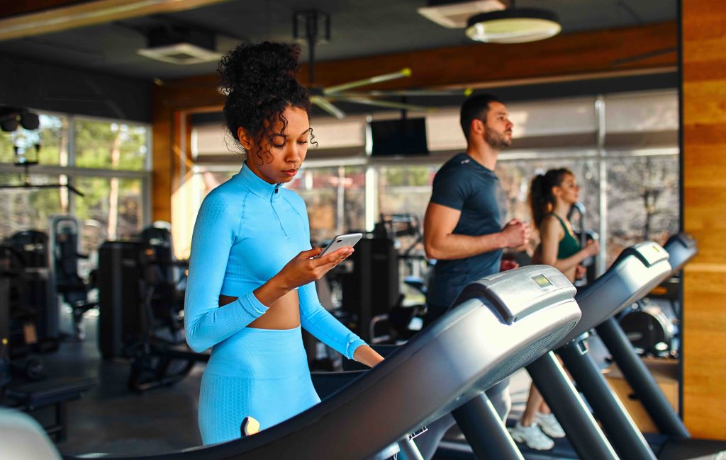 A member checking their phone while using the gym